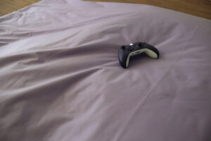 Videospielcontroller auf einem Bettlaken liegend 