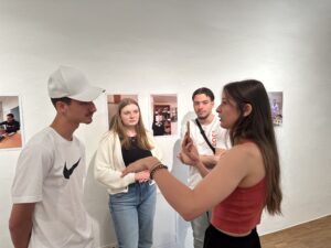 Gruppe vor Wand mit Fotografien 